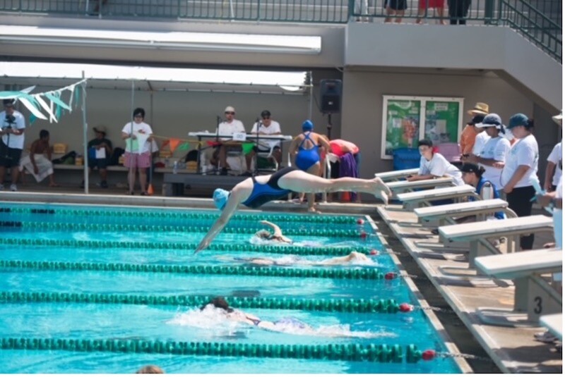 A Special Olympics athlete dives into a swimming pool.
