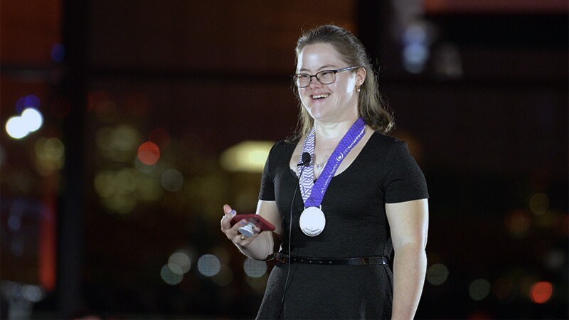 Melissa on stage with a medal draped around her neck speaking at SOMA's 50th Anniversary in 2018.