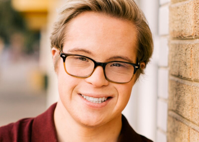 Professional head shot of Cole smiling wearing a burgundy polo. 