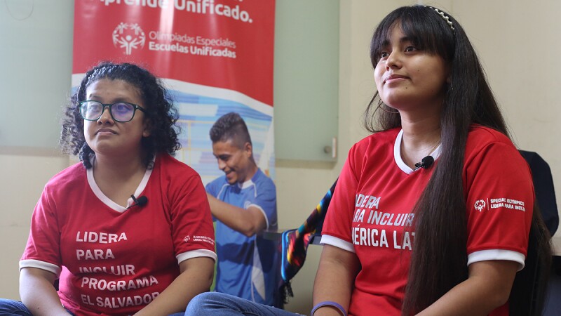 dos chicas con camisetas rojo sentadas una al lado de la otra