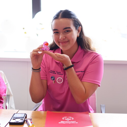 Young woman smiling and showing off a rubber duckie. 