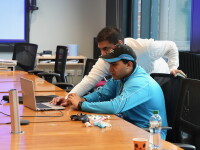 Two people at a table working on a computer. 