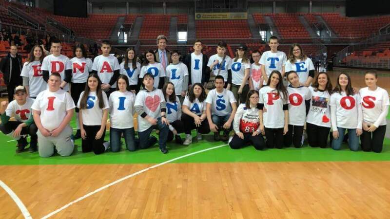 Un grupo de personas de pie o arrodilladas, en dos filas.