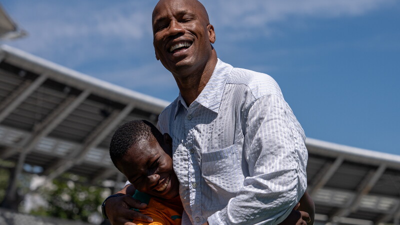 Two people hug in a football stadium