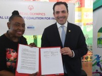 Two people standing side by side holding a document. 