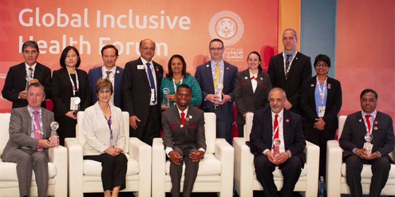 Youth leaders and health representatives sitting and standing on stage in a group shot.