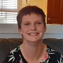 Lexi Dibbern sitting inside with a floral print shirt on.