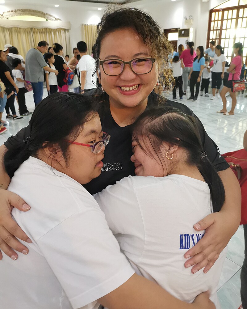 Kaye Hugging two young girls.