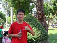 a young kid in a red shirt gives a thumbs up to the camera