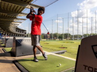 An athlete taking a swing at Topgolf. 