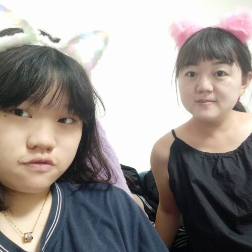 LI Zi Yu and her mother, Chen, wearing car ears while posing for a selfie together