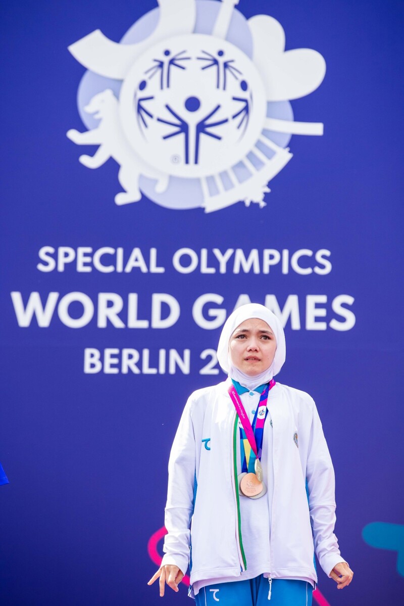 Athlete standing with four medals around their neck