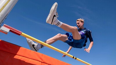 Man jumping over a bar. 