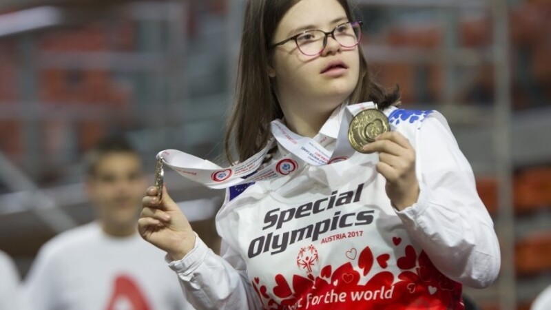 Una joven muestra su medalla.