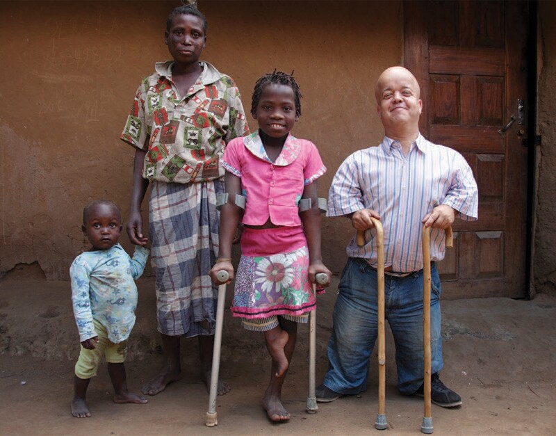 A young boy on the left hold a mother figures hand; a young girl with crutches dressed in floral and pink in the center; a young man with two canes standing and smiling.