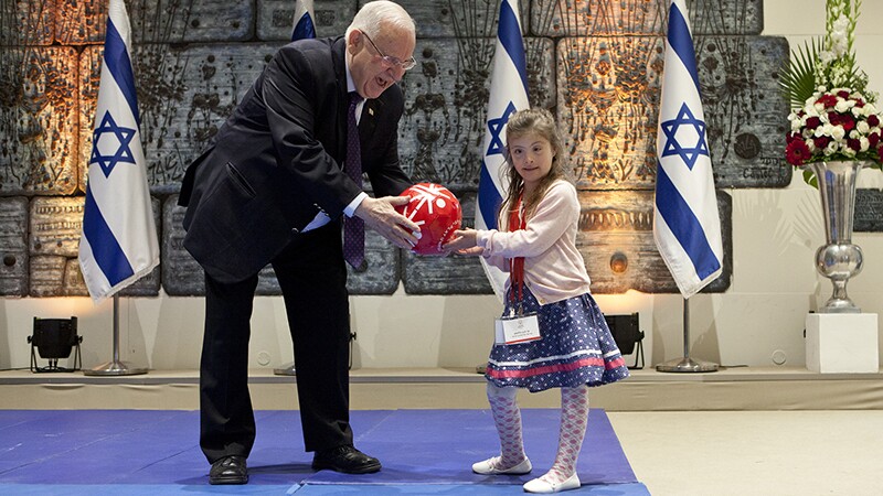 Shay Dagan Plessman presenting Israeli President Reuven Rivlin with a Special Olympics football.