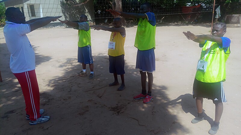 Young man showing four athletes a workout. 