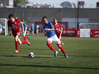 Footballers on the field going after the ball. 