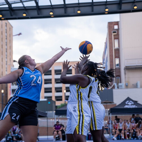 Three young women jumping for the basketball at tipoff. 