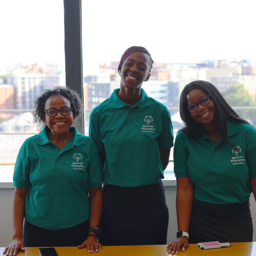 Three young women standing side by side and smiling. 