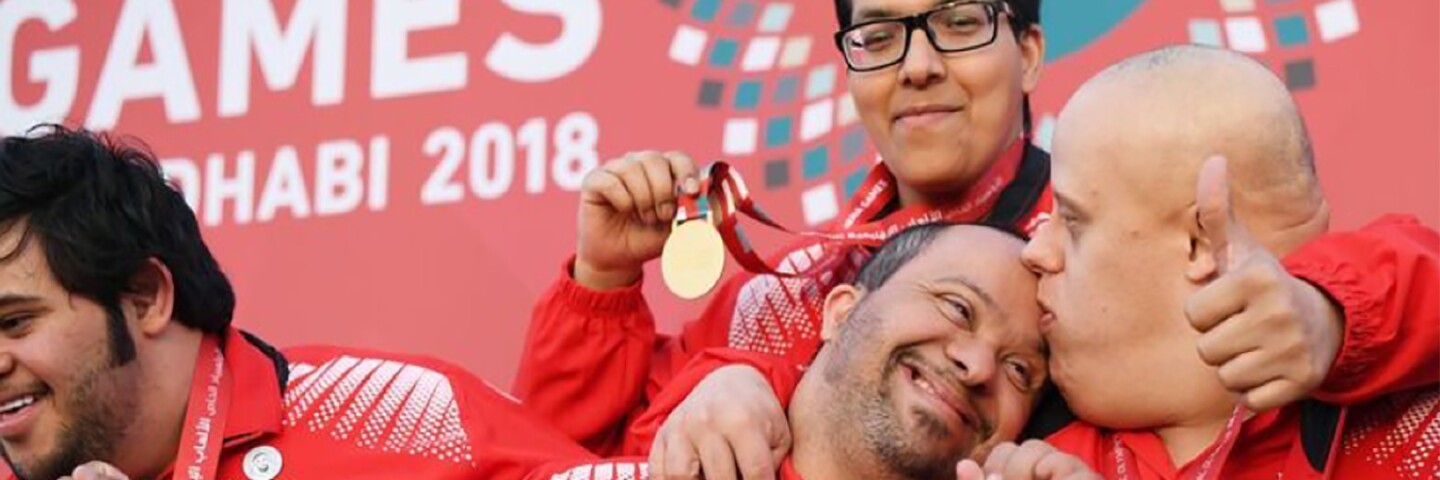Four athletes celebrating their gold medals on stage at the MENA Games in Abu Dhabi in 2018