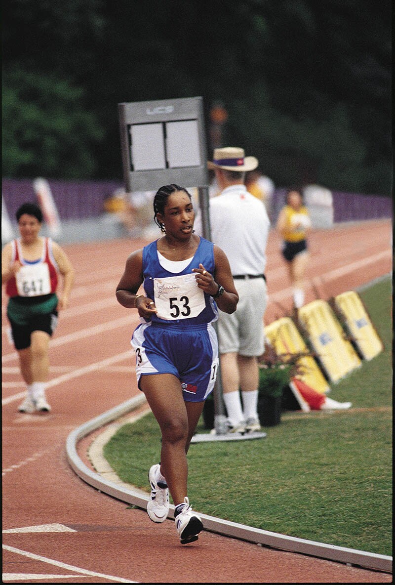 Loretta Claiborne of York, Pa., running on a track in blue shorts and tank top; her bib reads 53.
