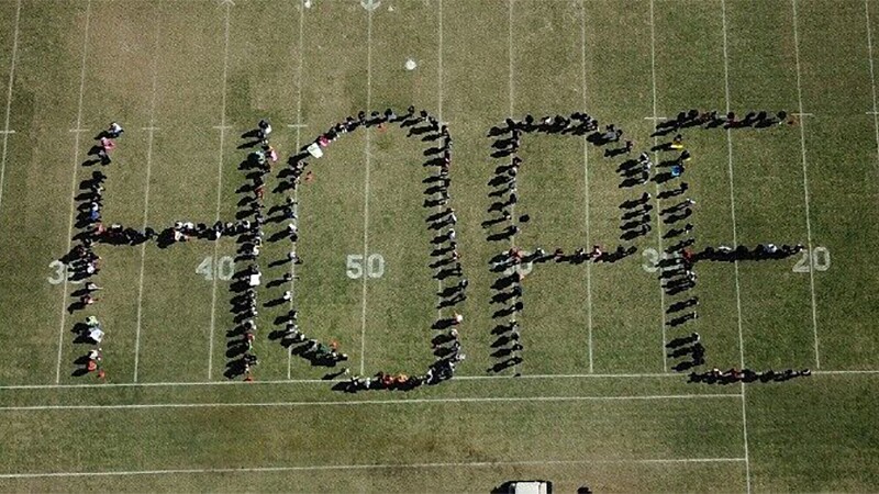 students spell out hope on a football field as part of anti- bullying campaign.