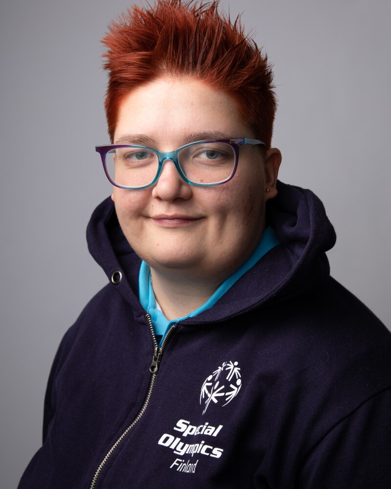 Headshot of red-haired woman wearing blue Special Olympics Finland jacket