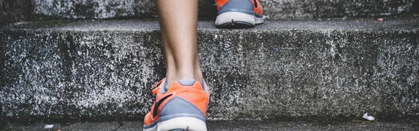 Young persons walking up stone steps in Nike sneakers.