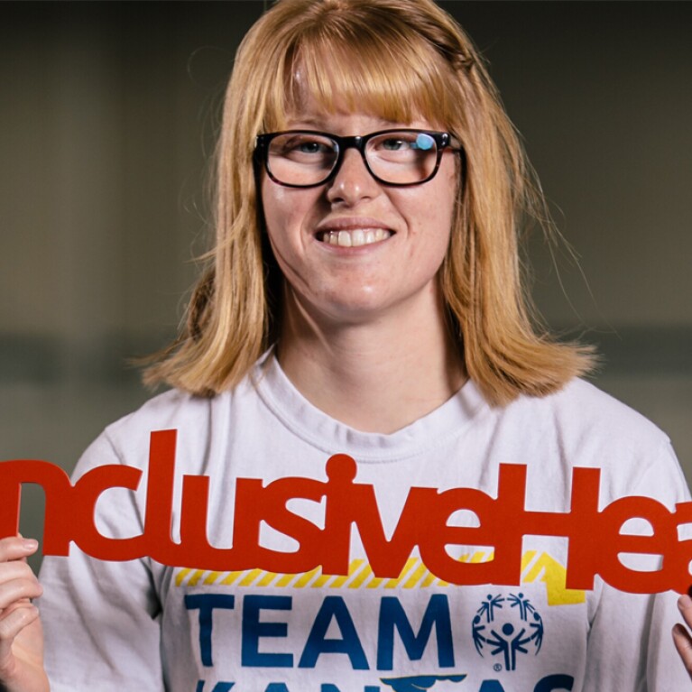 Woman holding "inclusive Health" sign