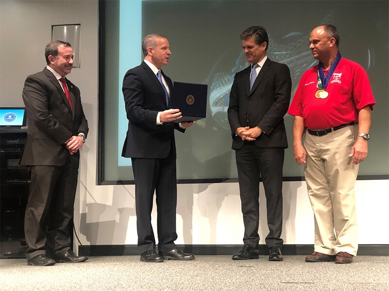 Kevin Brown standing with Tim Shriver and two FBI representatives.