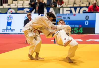 Two judokas in the middle of their match on the tatami.