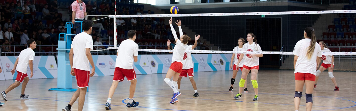 Two unified volleyball teams playing on the court.
