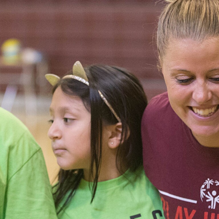 Three middle school children with green "RESPECT" t-shirts standing next to an adult woman.