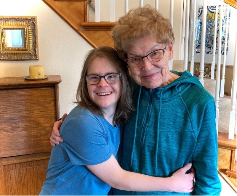 Two women embrace for a picture. 