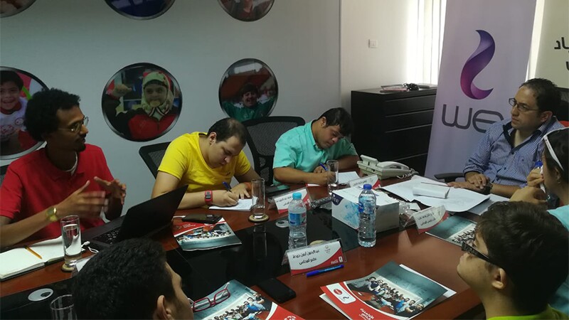 Group of people sitting around a table talking. 