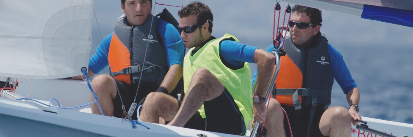 Athlete sailing while his team assists.