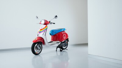 red vespa cycle with white and rainbow on front