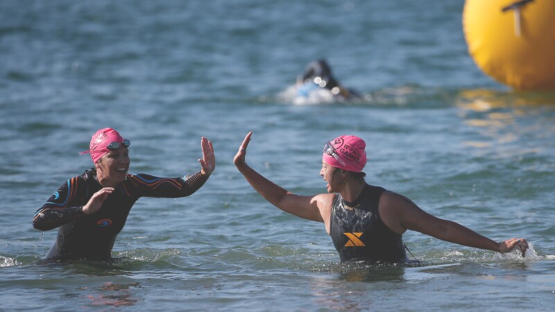 Two female players give one another a high-5 as they come out of the water.