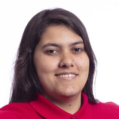 Emanuella standing for a professional photo wearing a red long sleeve Special Olympics polo.