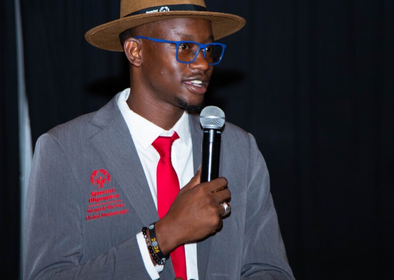 Hombre joven de pie en un podio hablando.