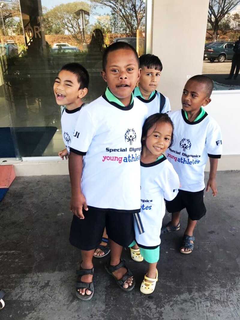 5 young children part of the Special Olympics program are “young athletes” at the recent workshop in Fiji satnding outside in a group, all young athletes have on Special Olympics Young Athletes white t-shirts.