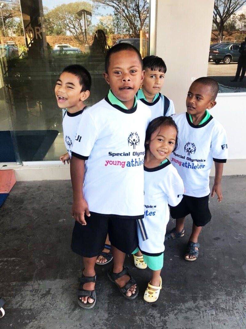 5 young children part of the Special Olympics program are “young athletes” at the recent workshop in Fiji satnding outside in a group, all young athletes have on Special Olympics Young Athletes white t-shirts. 