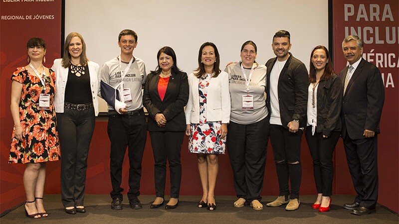 Group of nine people standing side by side for a group photo.
