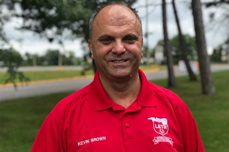 Kevin Brown standing outside in a red LETR polo shirt.