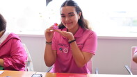 Young woman smiling and showing off a rubber duckie. 