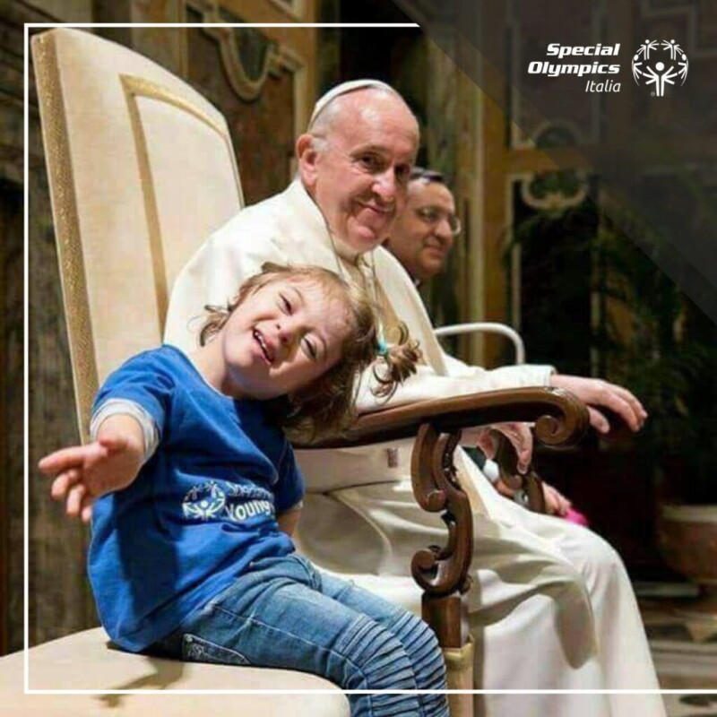 Pope Francis sat next to a child