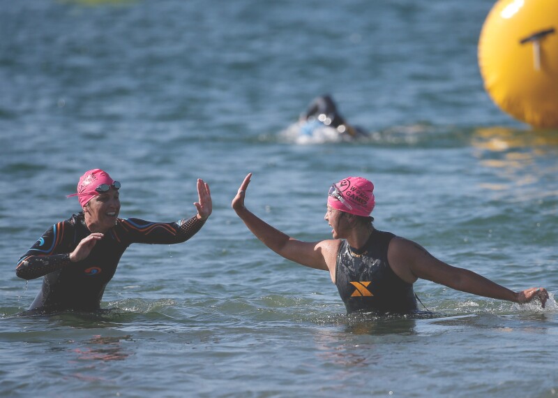 Two female players give one another a high-5 as they come out of the water.