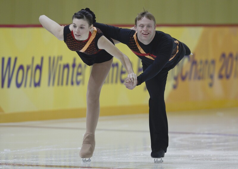 Female and male skating pair performing on the ice.