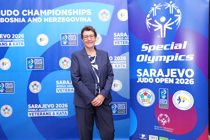 A woman in a suit, standing. 